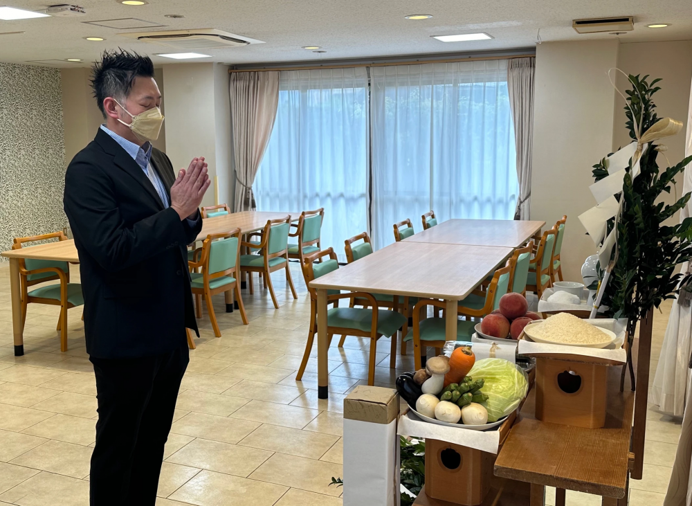 祈祷式の祭壇前でお祈りする社員